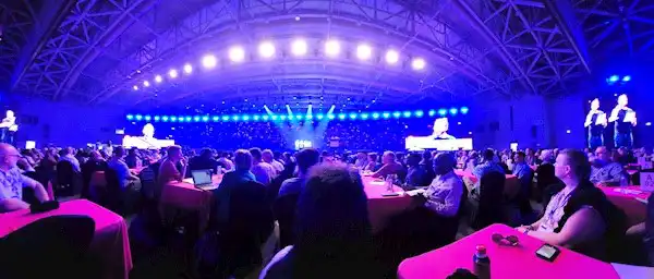 A group of people sitting at tables in a room with lights   