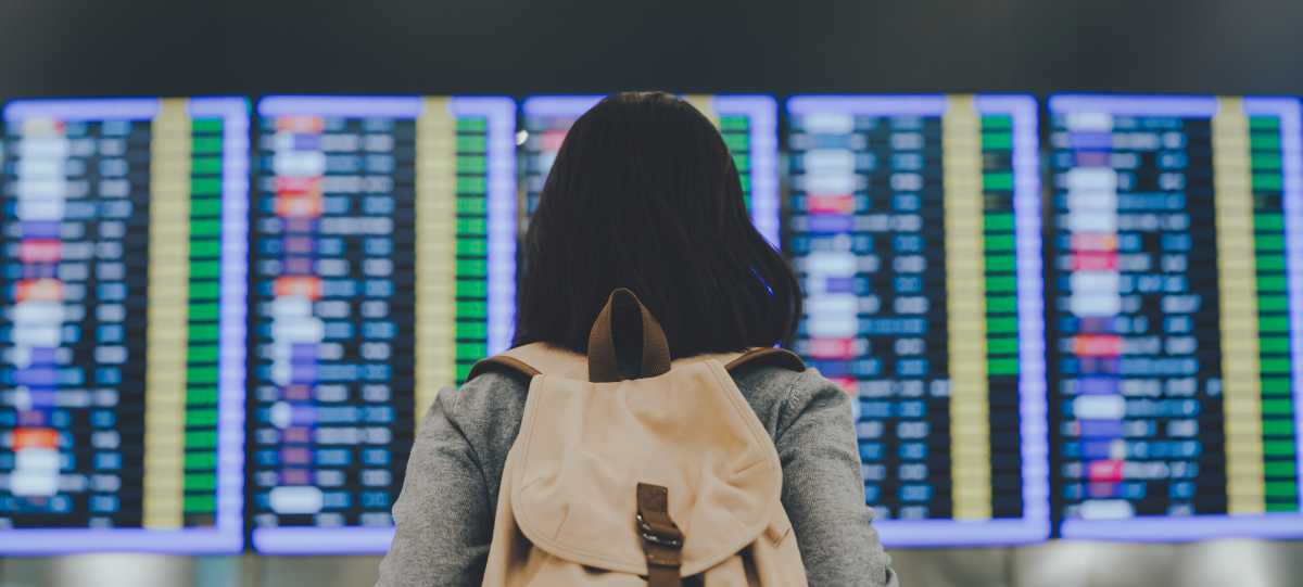 Woman looking at Airport arrival and departure display Woman looking at Airport arrival and departure display